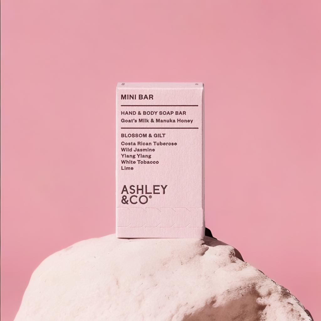 A product standing on a white rock, pink background, product photography